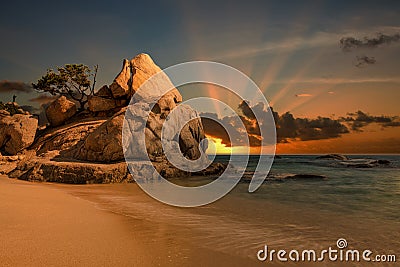 Beautiful shot of sunset at the rocky beach Stock Photo