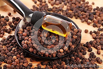 Whole black pepper and oil Stock Photo