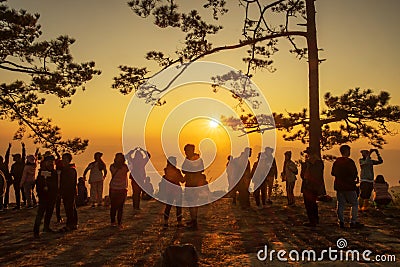 Beautiful Silhouette of hiker enjoy mist and sunrise at Nok Aen Cliff, Phu of Kradueng national park, Loei, Thailand Editorial Stock Photo