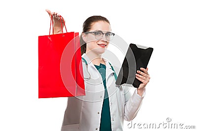 Attractive caucasian brunette confident female doctor standing in office with shopping bag and tablet in her hands on Stock Photo