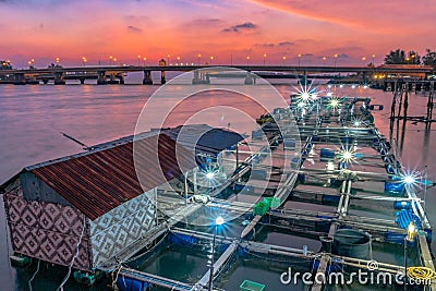 Beautiful sky during sunset going down to the sea above fish cage beside Sarasin Stock Photo