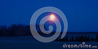 A beautiful skyscape with a moon in the dark skies. Springtime scenery before the dawn with moon. Stock Photo