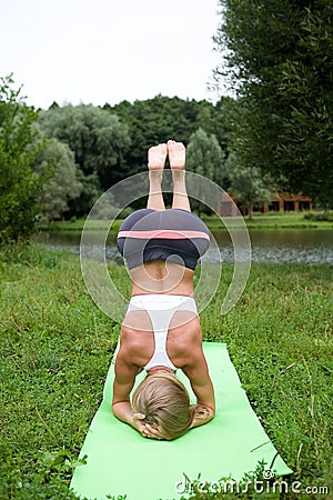 Beautiful slender girl performs a yoga pose. Stock Photo