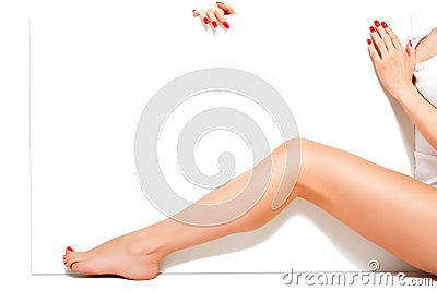 Beautiful slender woman with smooth skin and red manicure, sitting behind a banner Stock Photo