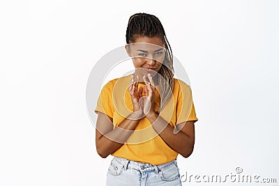 Beautiful sly girl scheming, steeple fingers and squinting suspicious, thinking, standing over white background Stock Photo