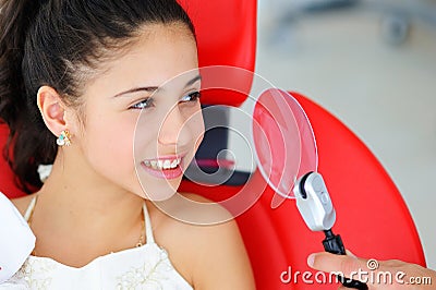 Beautiful smile with white teeth. A dentist examines the oral cavity of a young beautiful girl Stock Photo