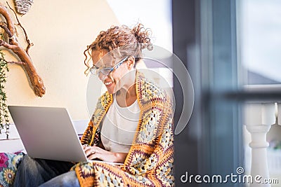 Beautiful smiled caucasian woman work with a laptop computer outdoor in the terrace. alternative office and lifestyle working at Stock Photo