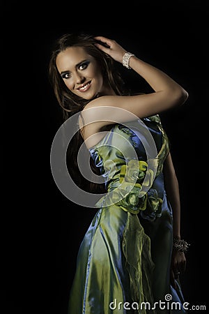 Beautiful smiliing brunette woman in green couture evening wear Stock Photo