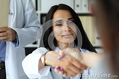 Beautiful smiling female GP shaking hands with visitor Stock Photo
