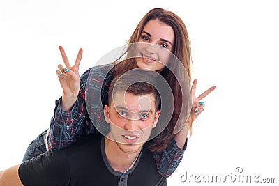 Beautiful smiling girl showing gestures of hands and climbed up on the back of young guy Stock Photo