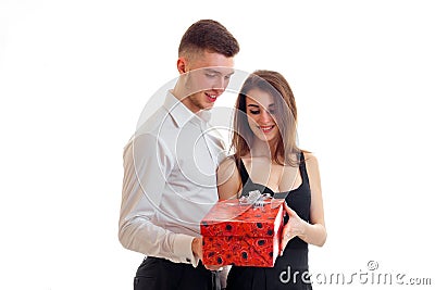 Beautiful smiling girl takes red gift that has brought young charming guy Stock Photo