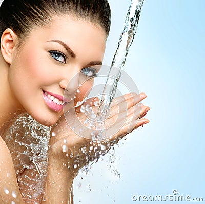 Beautiful smiling girl under splash of water Stock Photo