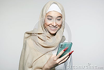 beautiful smiling islamic young woman with smartphone. beauty Happy girl in hijab Stock Photo