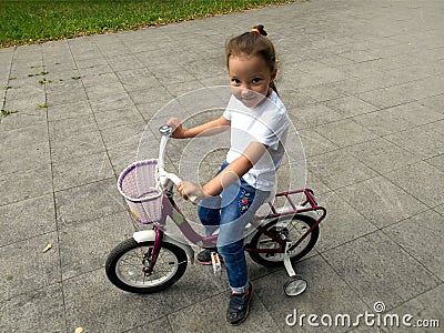 Beautiful smiling little girl riding bicycle Stock Photo