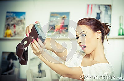 Beautiful, smiling red hair woman taking photos of herself with a camera. Fashionable attractive female taking a self portrait Stock Photo