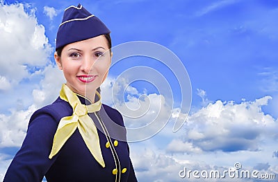 Beautiful smiling stewardess in uniform on a background sky Stock Photo