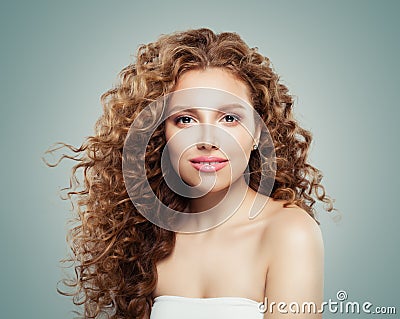 Beautiful smiling woman with healthy curly hair on gray background. Redhead girl Stock Photo