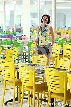 Beautiful smiling woman and posing for the camera among the multi-colored chairs. Stock Photo