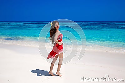 Beautiful smiling woman in red dress enjoying on exotic sea, tropical beach. summer outdoor portrait. Attractive girl model. Welln Stock Photo