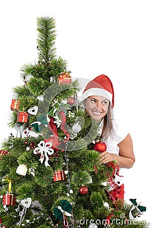 Beautiful smiling woman in Santa cap, behind the Christmas tree, isolated on white Stock Photo