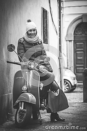 Beautiful smiling woman sitting on an old Italian motorcycle Editorial Stock Photo