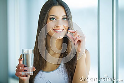 Beautiful Smiling Woman Taking Vitamin Pill. Dietary Supplement Stock Photo