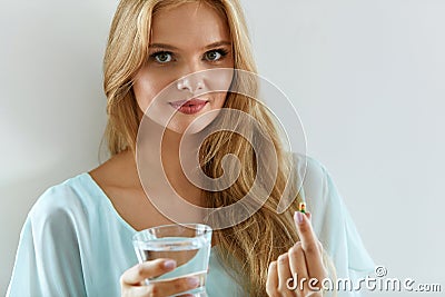 Beautiful Smiling Woman Taking Vitamin Pill. Dietary Supplement Stock Photo