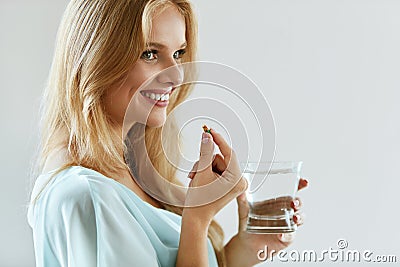 Beautiful Smiling Woman Taking Vitamin Pill. Dietary Supplement Stock Photo