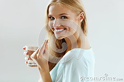 Beautiful Smiling Woman Taking Vitamin Pill. Dietary Supplement Stock Photo
