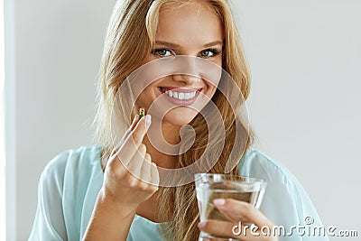 Beautiful Smiling Woman Taking Vitamin Pill. Dietary Supplement Stock Photo