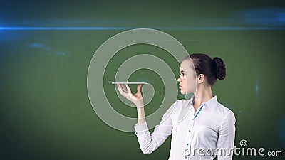 Beautiful smiling woman turning head and holding a tray,looking at something. Isolated studio background with copyspace. Stock Photo