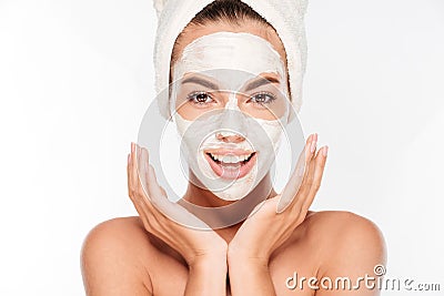 Beautiful smiling woman with white clay facial mask on face Stock Photo