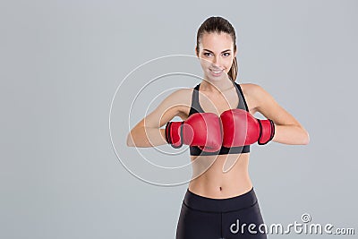 Beautiful smiling young fitness woman wears red boxing gloves Stock Photo