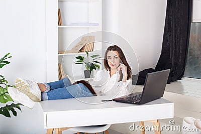 Beautiful smiling young girl working at home - freelancer. Routine work every day in the office. Rest from office work. Positive y Stock Photo