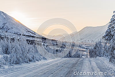 beautiful snow covered winter road with road sign and trees in mountains, Stock Photo