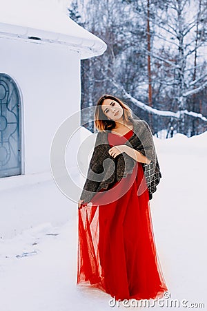 Beautiful snow maiden girl with red hair on february nature. Snow fall in february. Long retro gown Stock Photo