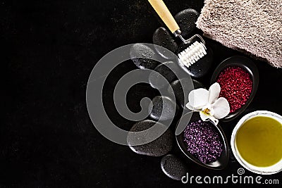 Beautiful Spa Set Spa Products with Essential Oils, Soap, Towel, Spa Sea Salt on Dark Wet Background. Horizontal with Copy Space. Stock Photo