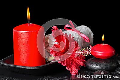 Beautiful spa still life of red hibiscus flower with dew, candle Stock Photo