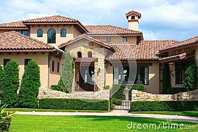 Beautiful Spanish style house exterior with natural rock facing and veneer siding Stock Photo