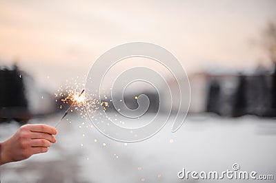 Beautiful sparklers in the hands of a girl on a city background, holiday and Christmas and New Year concept Stock Photo