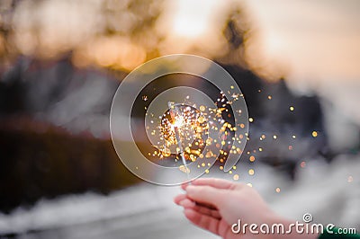 Beautiful sparklers in the hands of a girl on a city background, holiday and Christmas and New Year concept Stock Photo