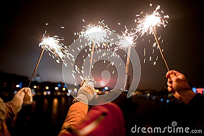 beautiful sparklers in woman hands on dark background Stock Photo