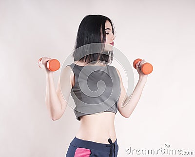 Beautiful sports girl muscular dumbbells studio Stock Photo