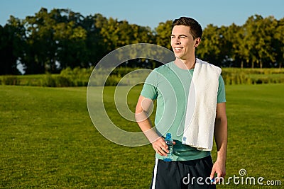 Beautiful sportsman drinking water on the nature. Stock Photo