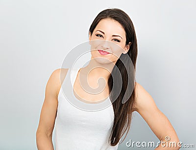 Beautiful sporty laughing woman with hand under the face thinking and looking in casual white t-shirt and long hair on blue Stock Photo