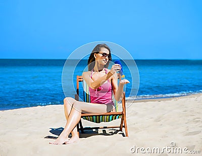Beautiful, sporty and young woman in swimsuit using sun tan Stock Photo