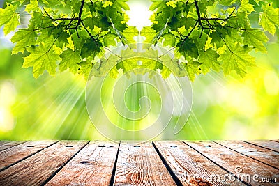 Beautiful spring background with green juicy foliage and empty wooden table in nature outdoor. Beauty bokeh and sunlight Stock Photo