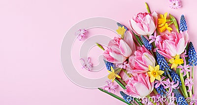 Beautiful spring flowers on pastel pink table top view. Greeting card or banner for International Women Day. Flat lay Stock Photo