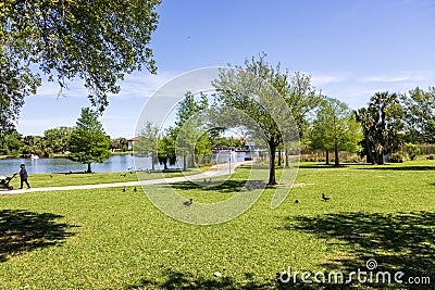 A beautiful spring landscape at New Orleans City Park with people, lush green trees, grass and plants, a lake, birds and blue sky Editorial Stock Photo