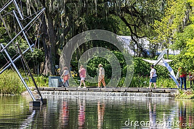 a beautiful spring landscape in the Sculpture Garden at New Orleans City Park with a lake, lush green trees, grass and plants Editorial Stock Photo